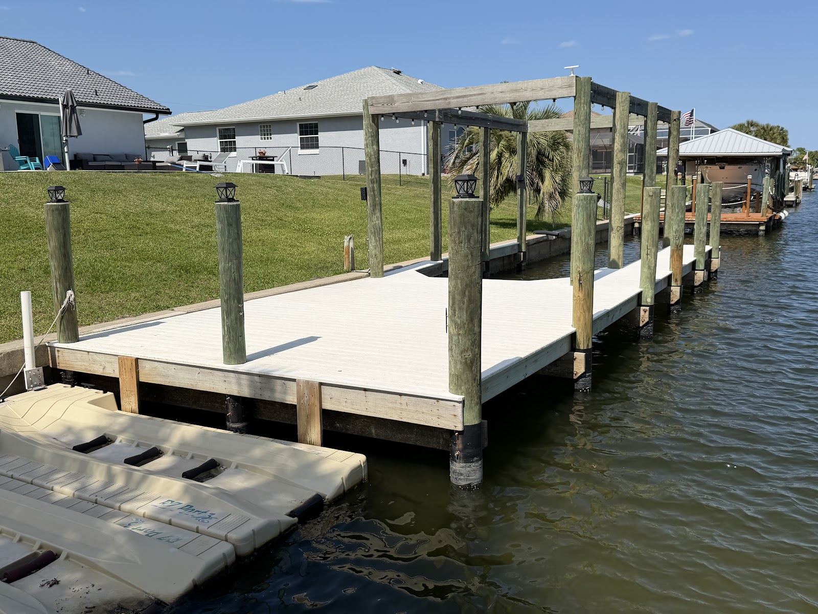 Custom composite dock with pergola frame and PWC lift on Florida canal