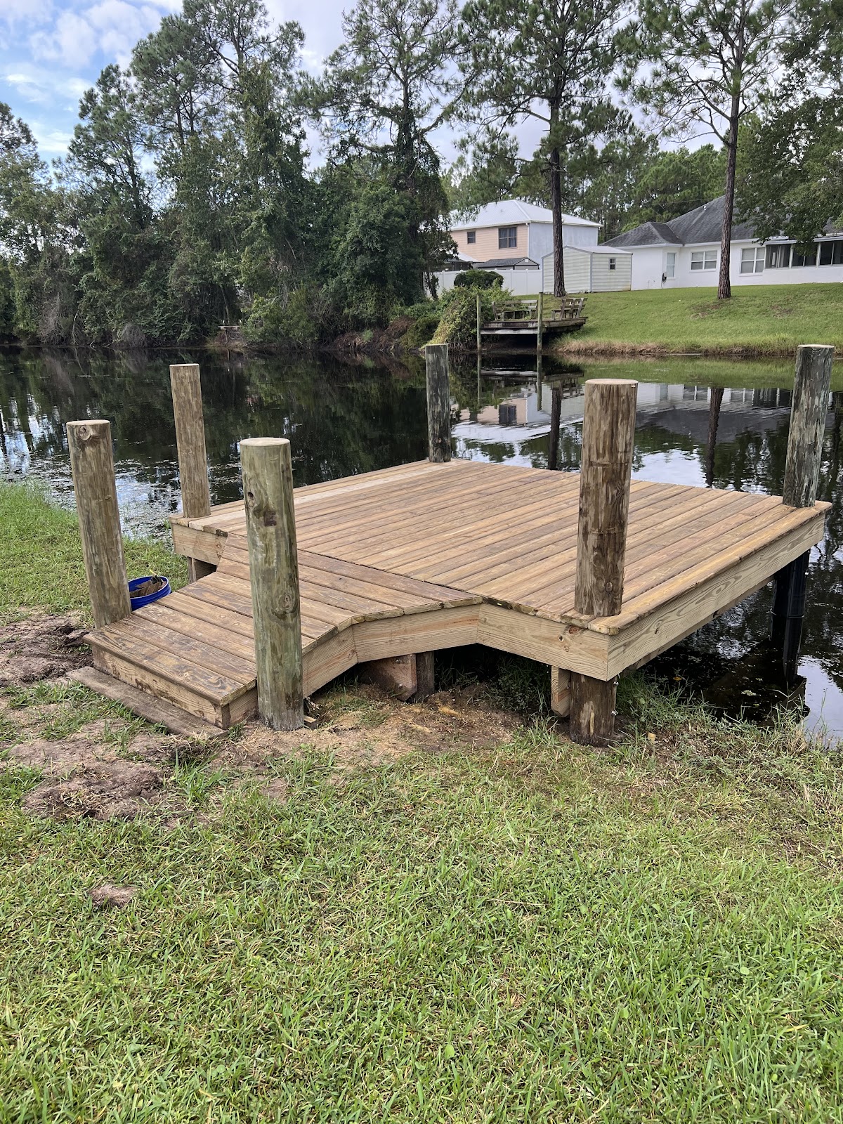 Pressure-treated wood dock freshly built on quiet Florida waterway
