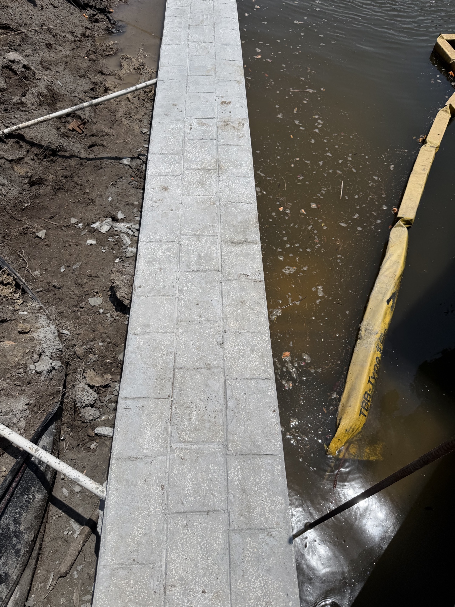 Custom stamped concrete seawall cap with tile pattern detail